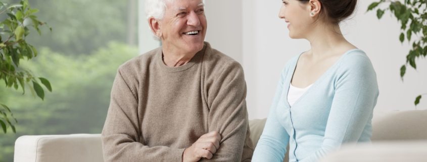 happy old man smiling to young woman